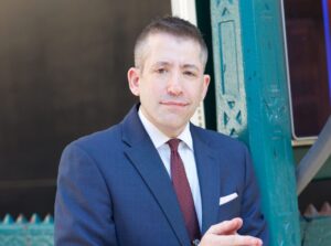 Man in navy suit and maroon tie